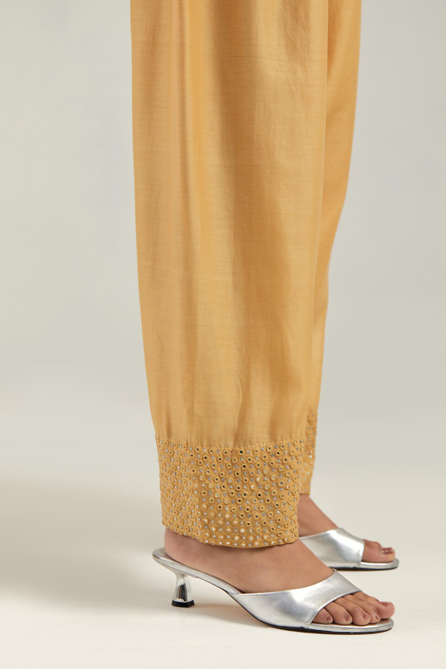 Yellow silk Chanderi salwar with hand-embroidered mirror & sequins work in a broad border at the hem.