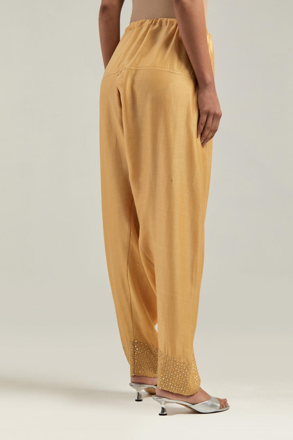 Yellow silk Chanderi salwar with hand-embroidered mirror & sequins work in a broad border at the hem.