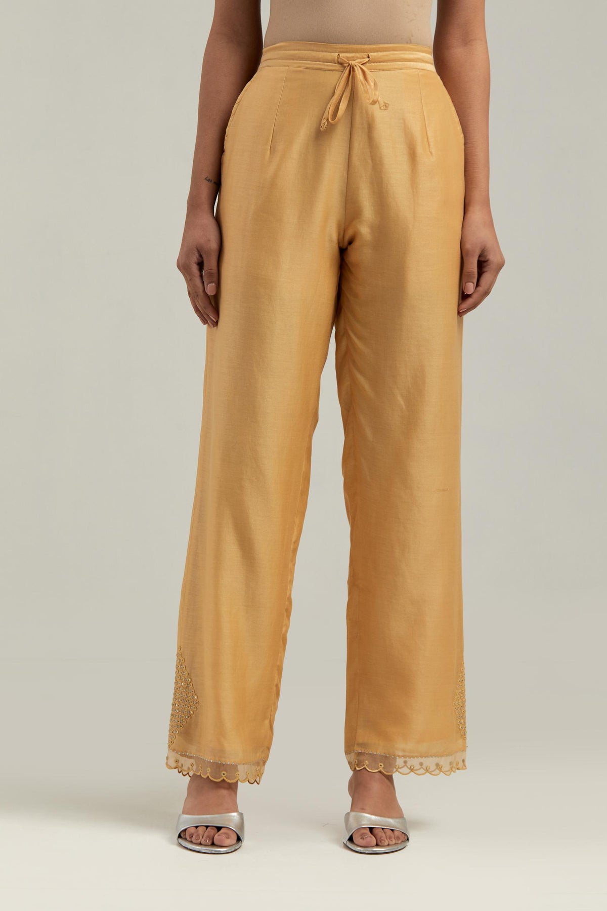 Yellow silk Chanderi straight pants with narrow organza scalloped hem and hand-embroidered diamond motifs with delicate mirror & sequins work at the sides.