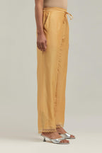 Yellow silk Chanderi straight pants with narrow organza scalloped hem and hand-embroidered diamond motifs with delicate mirror & sequins work at the sides.