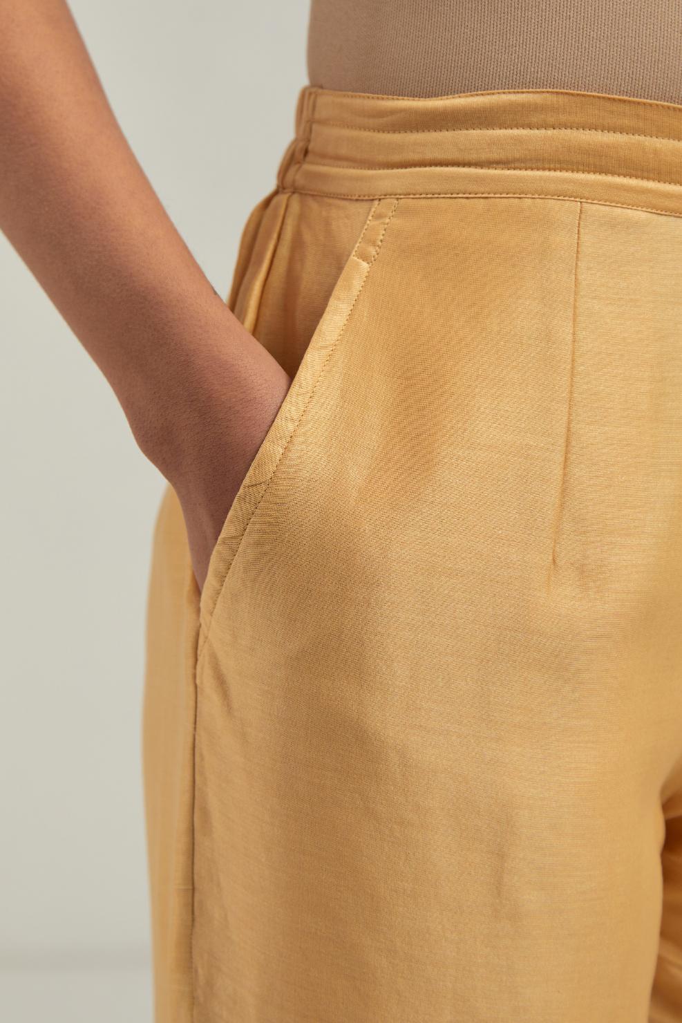 Yellow silk Chanderi straight pants with narrow organza scalloped hem and hand-embroidered diamond motifs with delicate mirror & sequins work at the sides.