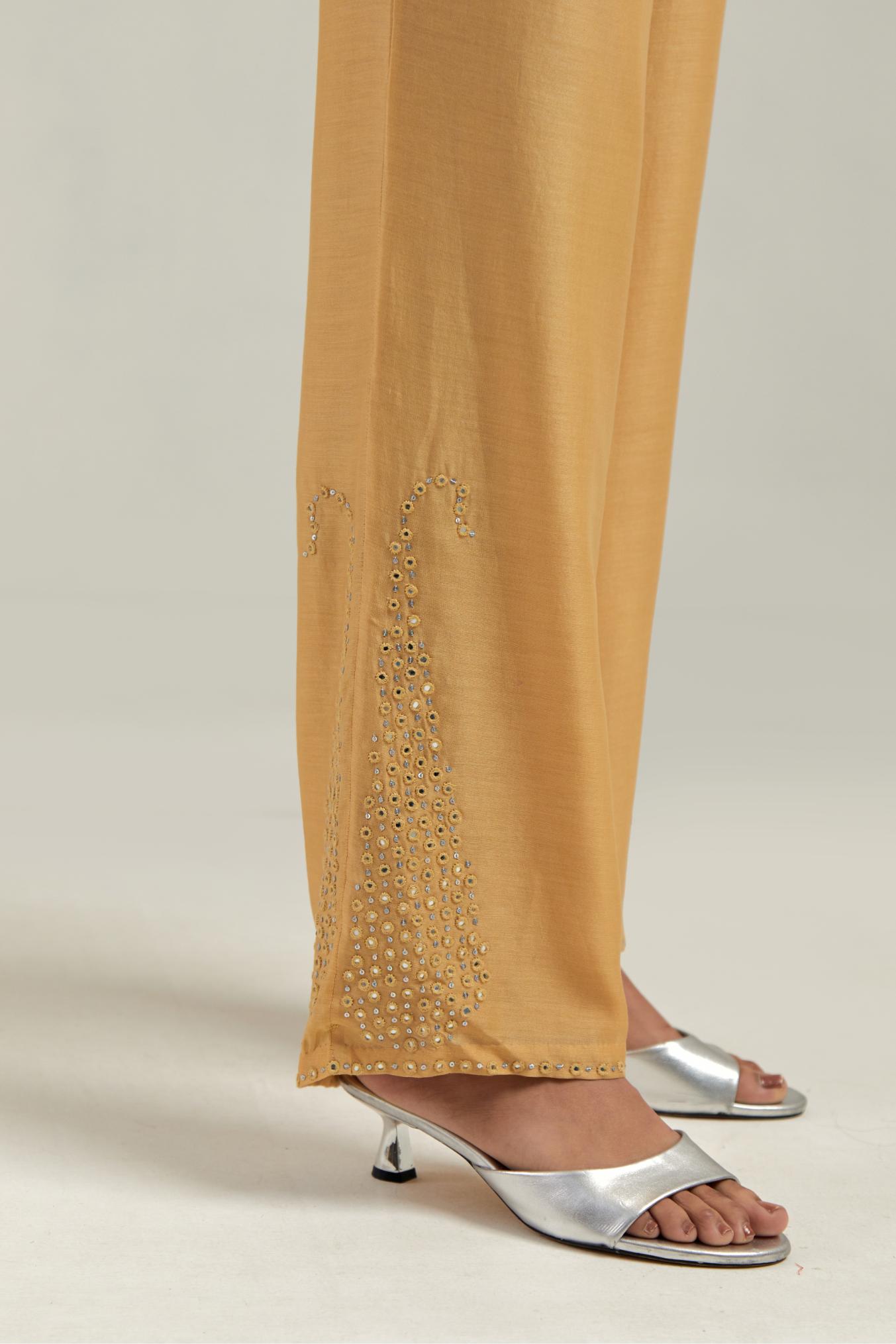 Yellow silk Chanderi pants with hand-embroidered paisley motifs with delicate mirror and sequins work at the hem.