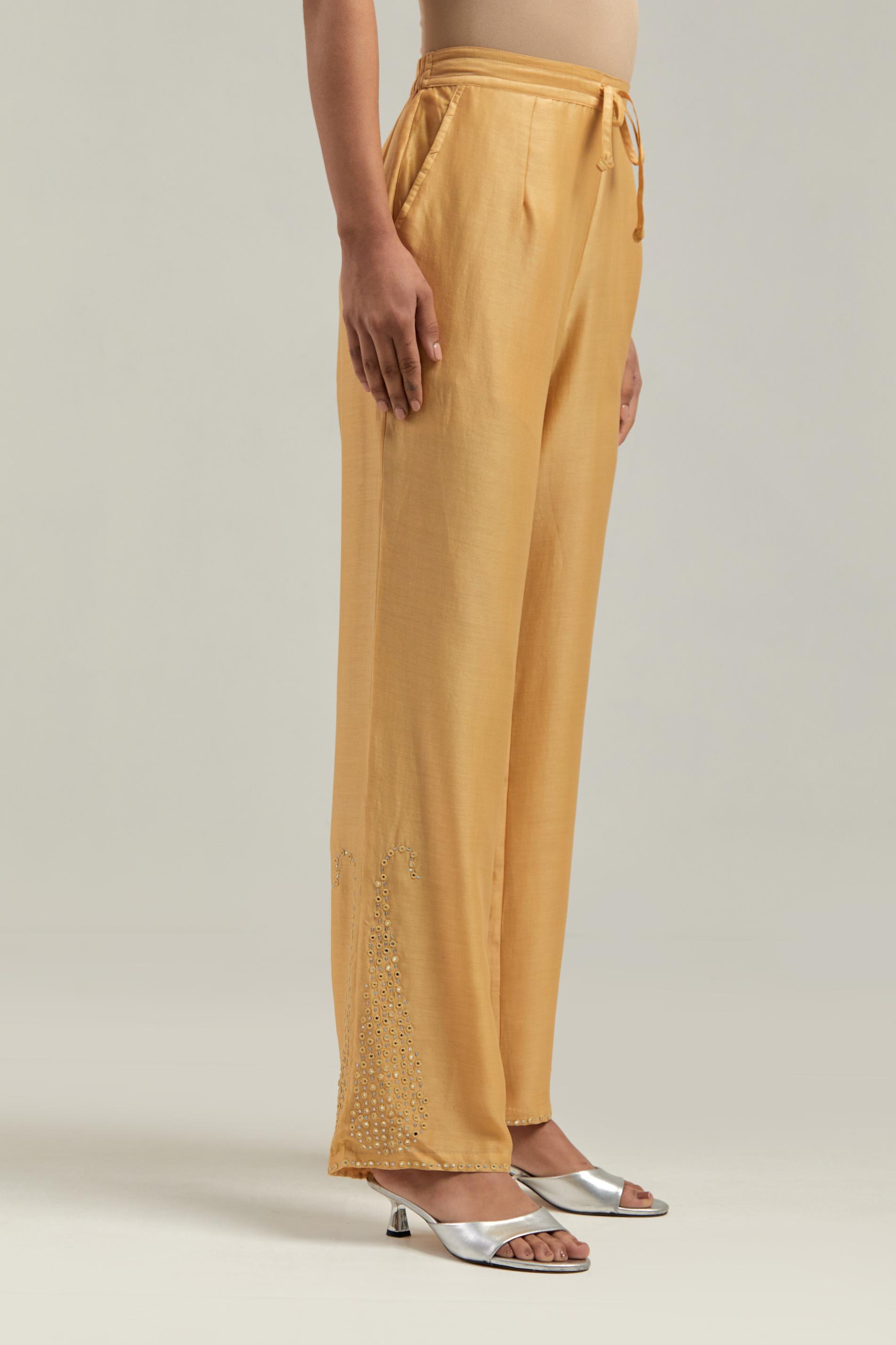 Yellow silk Chanderi pants with hand-embroidered paisley motifs with delicate mirror and sequins work at the hem.
