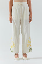Off white cotton straight pants detailed with yellow & green colored applique, highlighted with bead & sequins work.