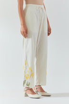 Off white cotton straight pants detailed with yellow & green colored applique, highlighted with bead & sequins work.