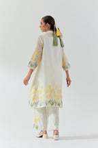 Off white cotton chanderi A-line short kurta set with yellow & green applique work at hem, highlighted with bead & sequins work.