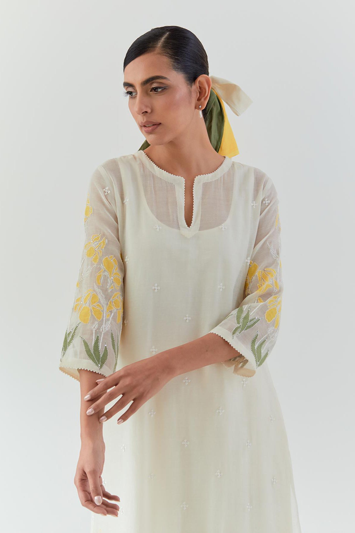 Off white cotton chanderi straight kurta set, decorated with yellow & green appliqué at the hem and sleeves.