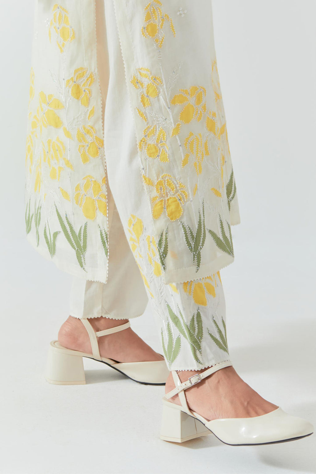 Off white cotton chanderi straight kurta set, decorated with yellow & green appliqué at the hem and sleeves.
