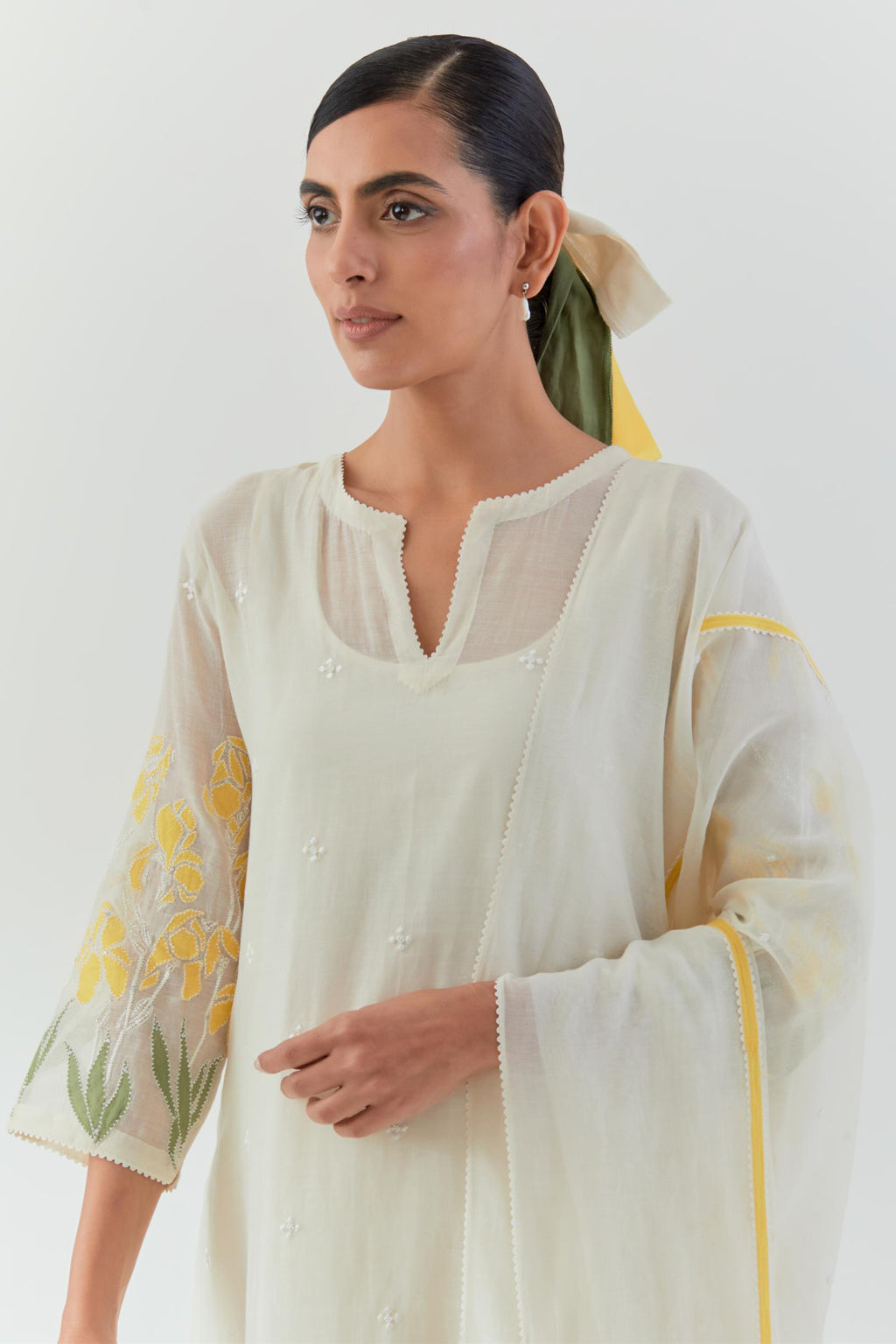 Off white cotton chanderi straight kurta set, decorated with yellow & green appliqué at the hem and sleeves.