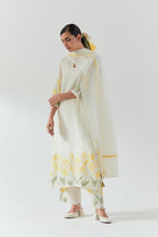 Off white cotton chanderi straight kurta set, decorated with yellow & green appliqué at the hem and sleeves.