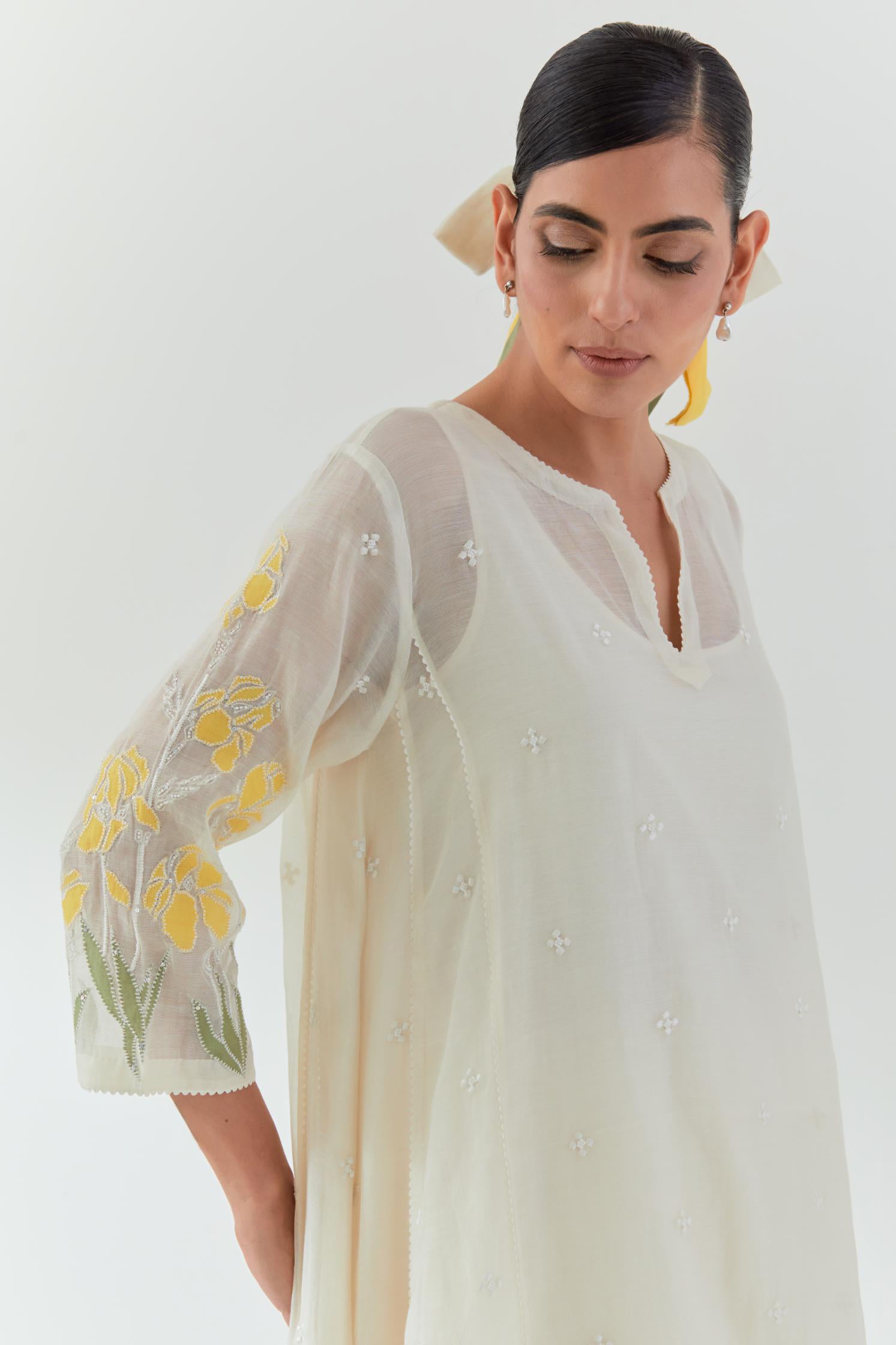 Off white cotton chanderi easy fit, asymmetric hem, paneled kurta set with yellow & green applique work at hem and sleeves.