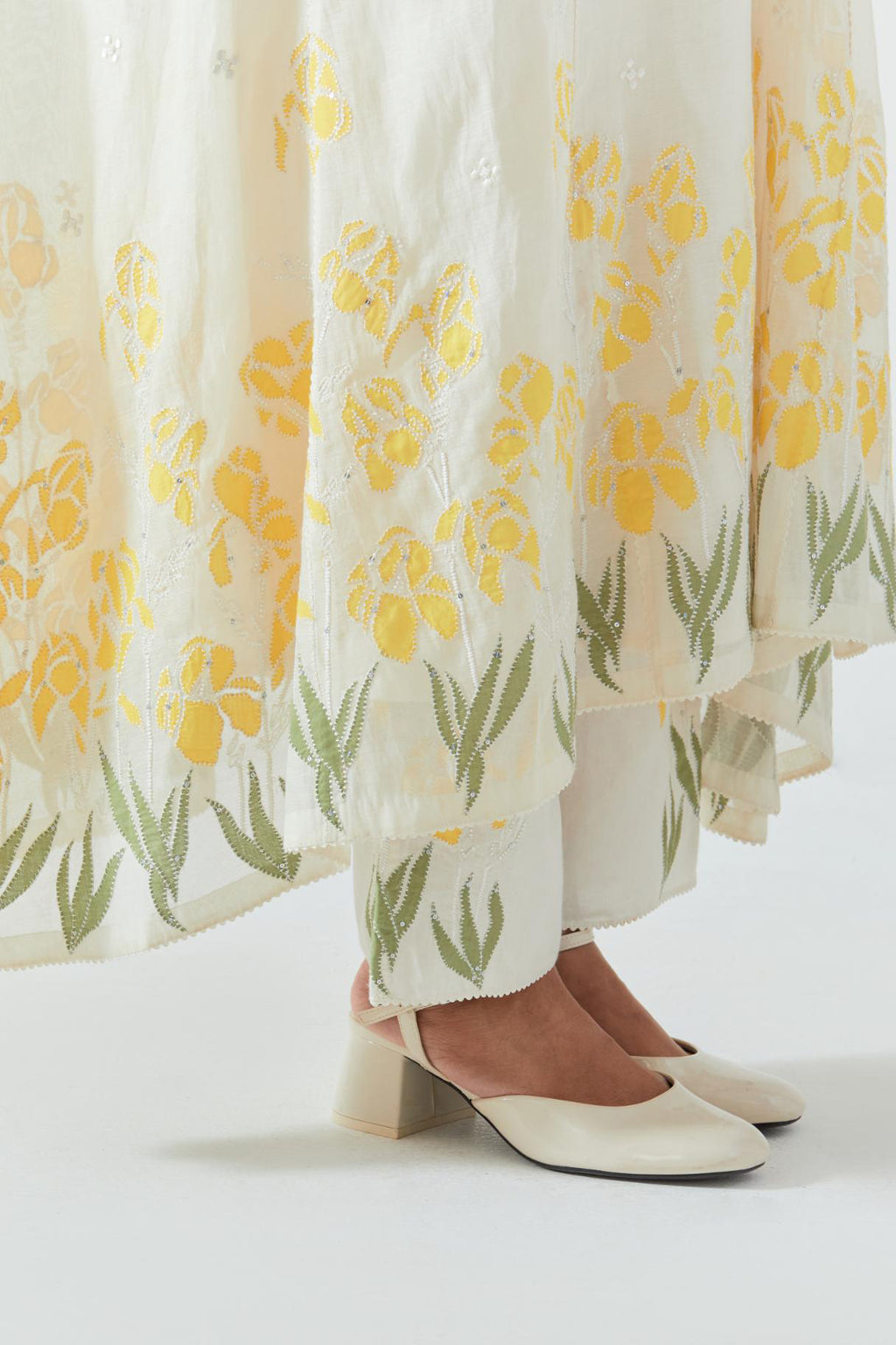 Off white cotton chanderi easy fit, asymmetric hem, paneled kurta set with yellow & green applique work at hem and sleeves.