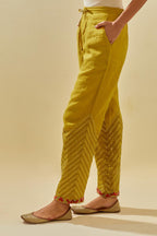 Yellow tissue chanderi straight pants with hand cut silk flower embroidery at hem, highlighted with gold sequins and beads.