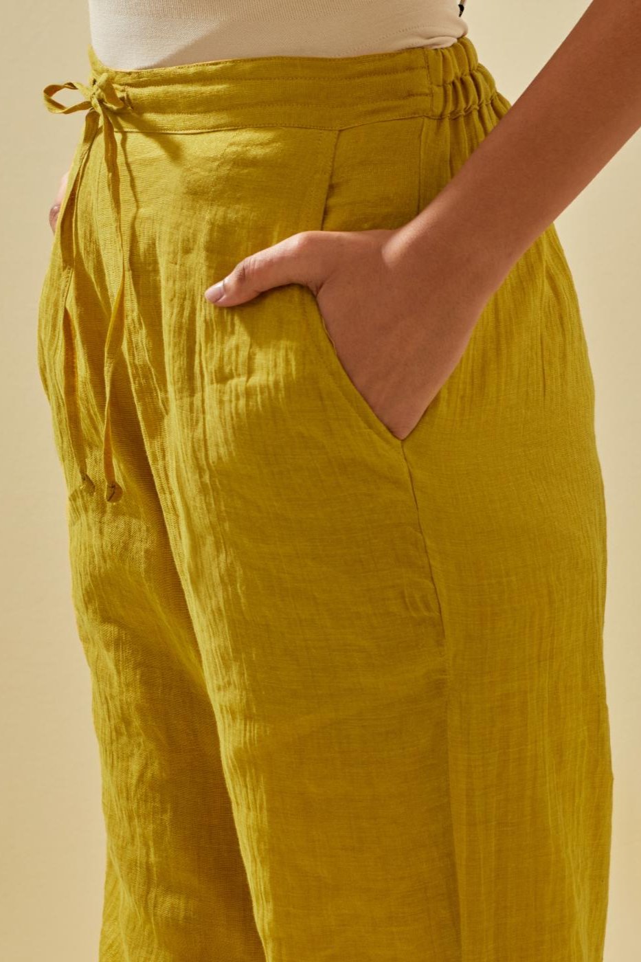 Yellow tissue chanderi straight pants with hand cut silk flower embroidery at hem, highlighted with gold sequins and beads.