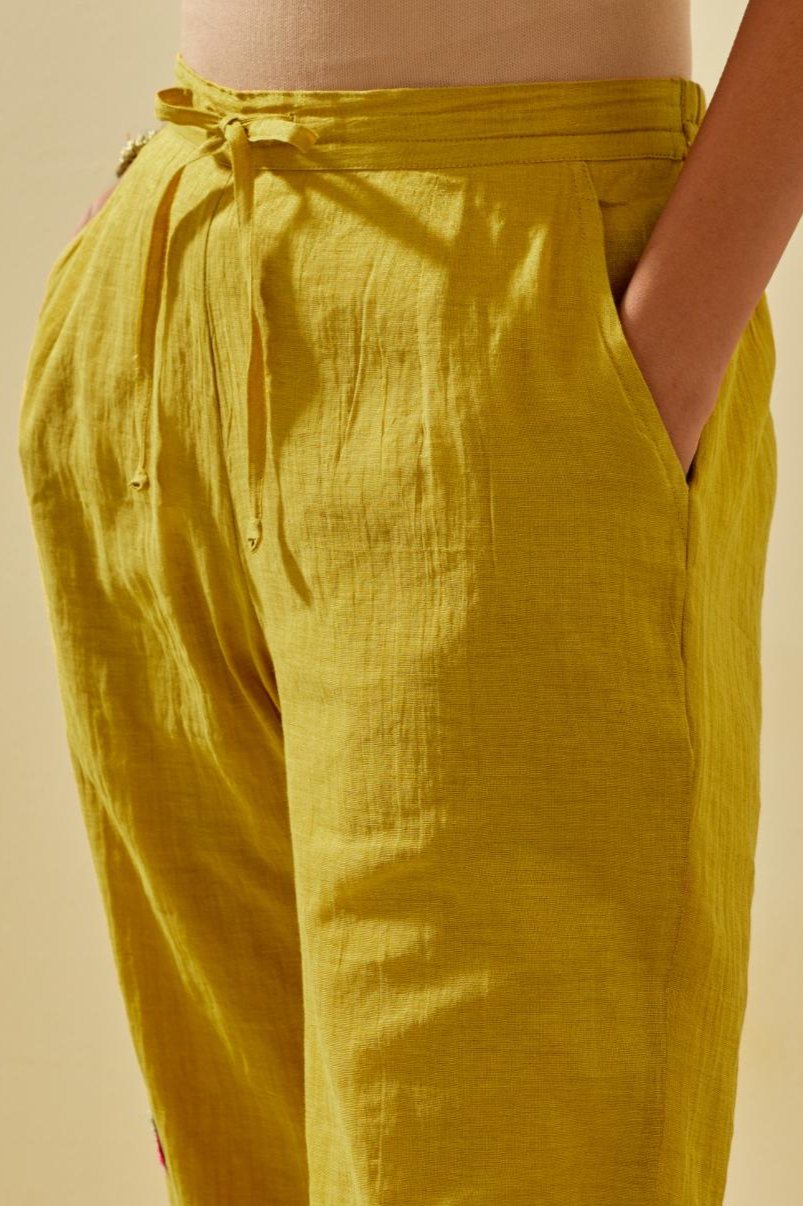 Yellow tissue chanderi straight pants with hand cut silk flower embroidered booti, highlighted with gold sequins.