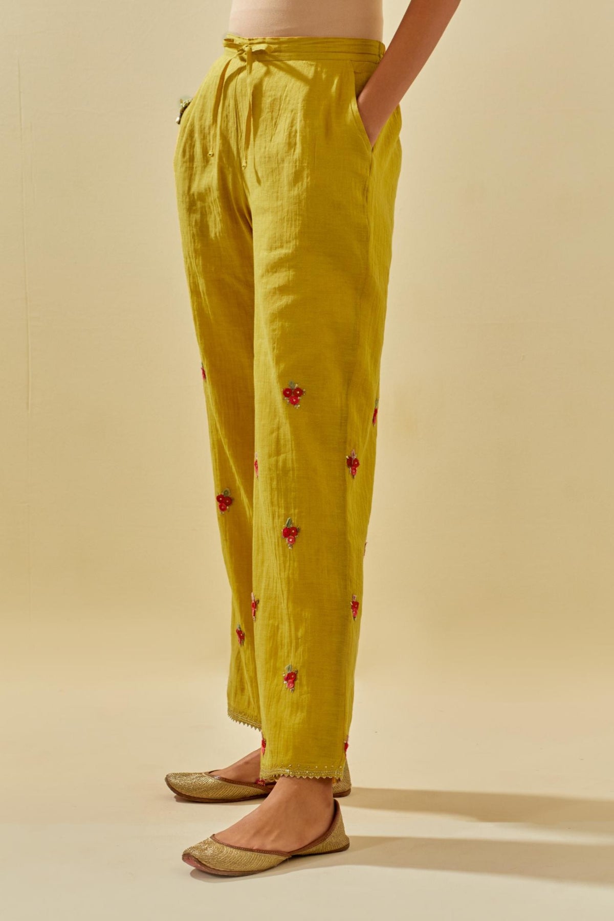 Yellow tissue chanderi straight pants with hand cut silk flower embroidered booti, highlighted with gold sequins.