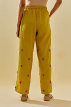 Yellow tissue chanderi straight pants with hand cut silk flower embroidered booti, highlighted with gold sequins.