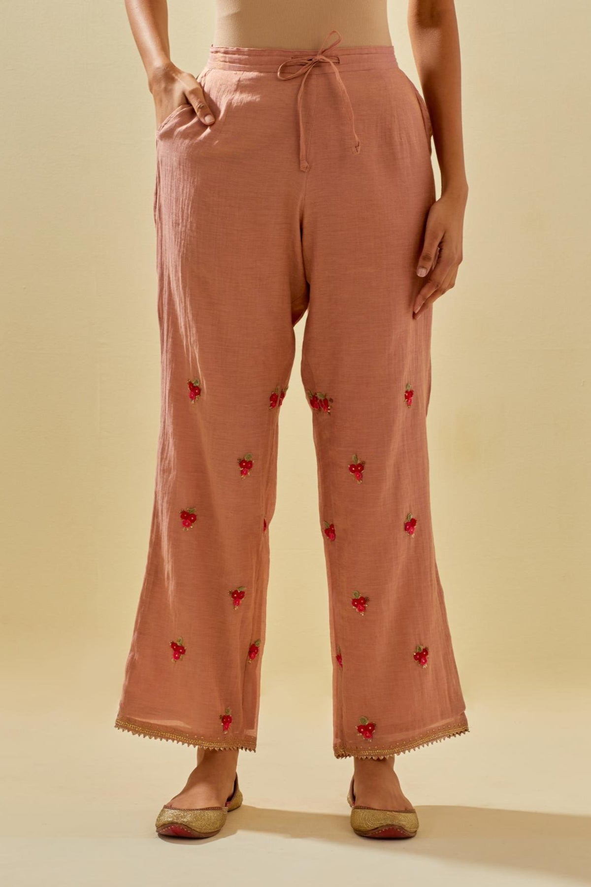 Pink tissue chanderi straight pants with hand cut silk flower embroidered booti, highlighted with gold sequins.