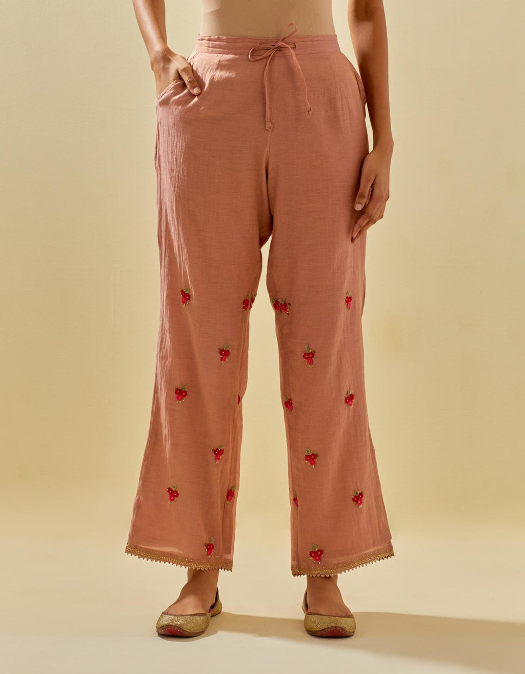 Pink tissue chanderi straight pants with hand cut silk flower embroidered booti, highlighted with gold sequins.