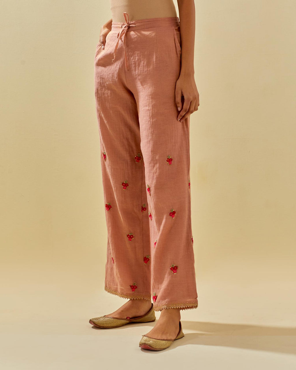 Pink tissue chanderi straight pants with hand cut silk flower embroidered booti, highlighted with gold sequins.