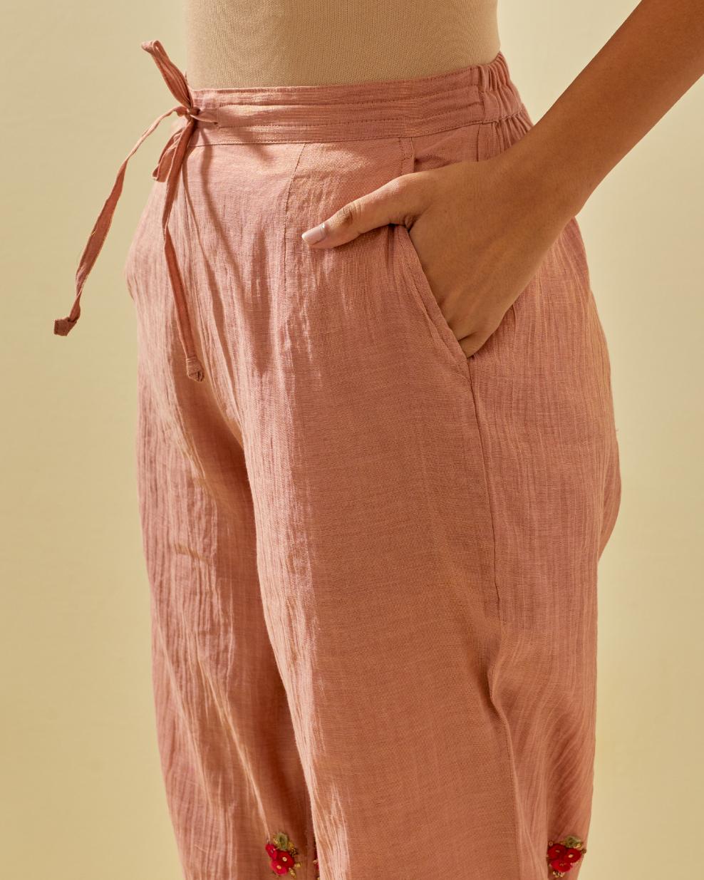Pink tissue chanderi straight pants with hand cut silk flower embroidered booti, highlighted with gold sequins.