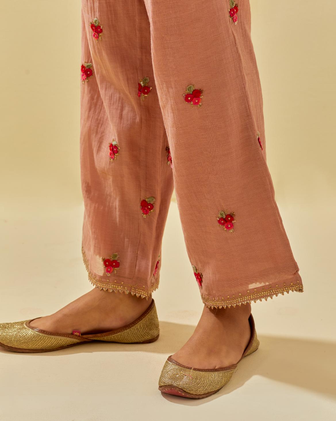 Pink tissue chanderi straight pants with hand cut silk flower embroidered booti, highlighted with gold sequins.