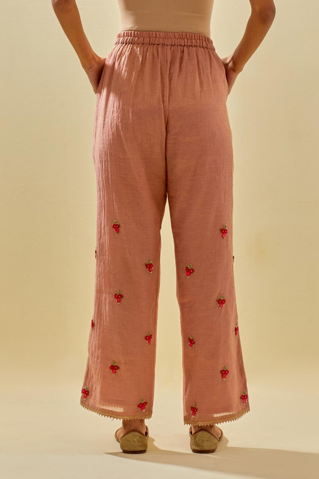 Pink tissue chanderi straight pants with hand cut silk flower embroidered booti, highlighted with gold sequins.