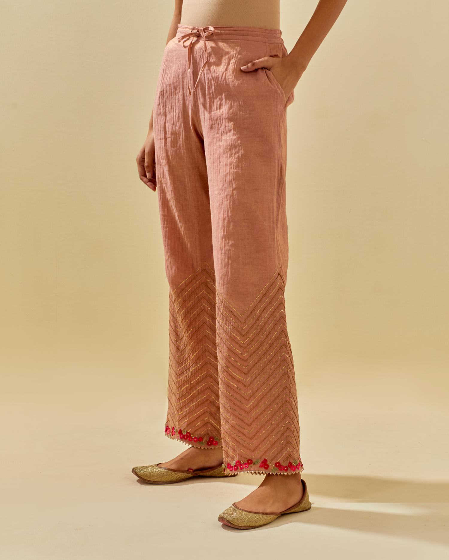 Pink tissue chanderi straight pants with hand cut silk flower embroidery at hem, highlighted with gold sequins and beads.