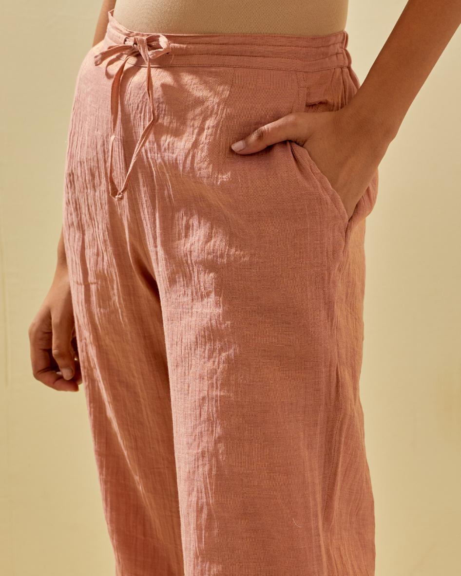 Pink tissue chanderi straight pants with hand cut silk flower embroidery at hem, highlighted with gold sequins and beads.