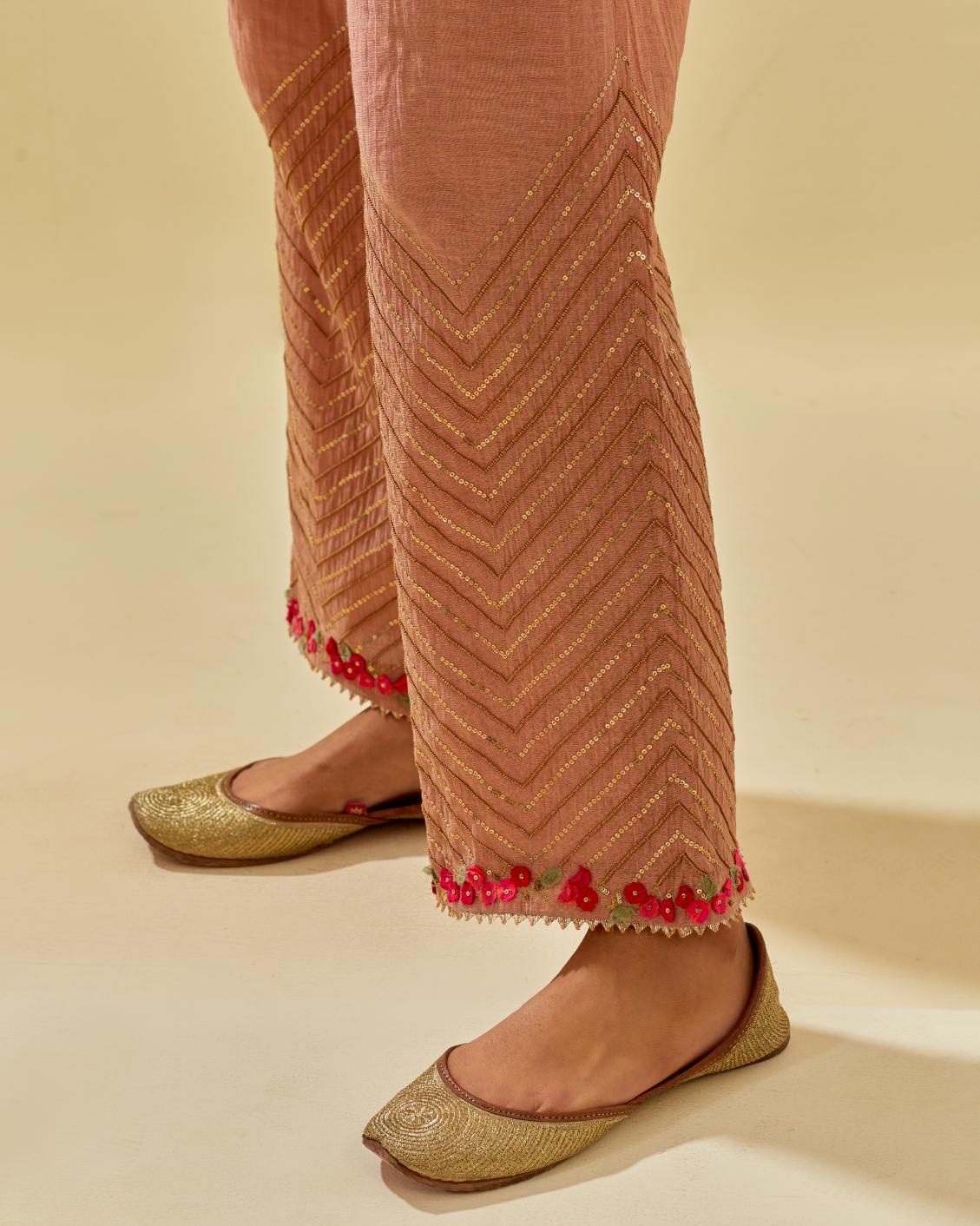 Pink tissue chanderi straight pants with hand cut silk flower embroidery at hem, highlighted with gold sequins and beads.
