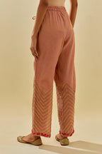 Pink tissue chanderi straight pants with hand cut silk flower embroidery at hem, highlighted with gold sequins and beads.