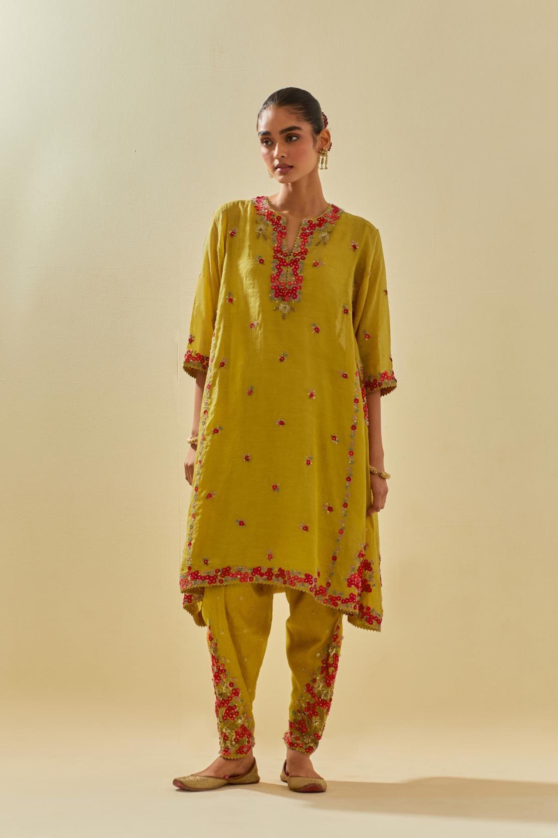 Yellow tissue chanderi mid length kalidar kurta set with hand cut silk flower embroidery, highlighted with gold sequins.