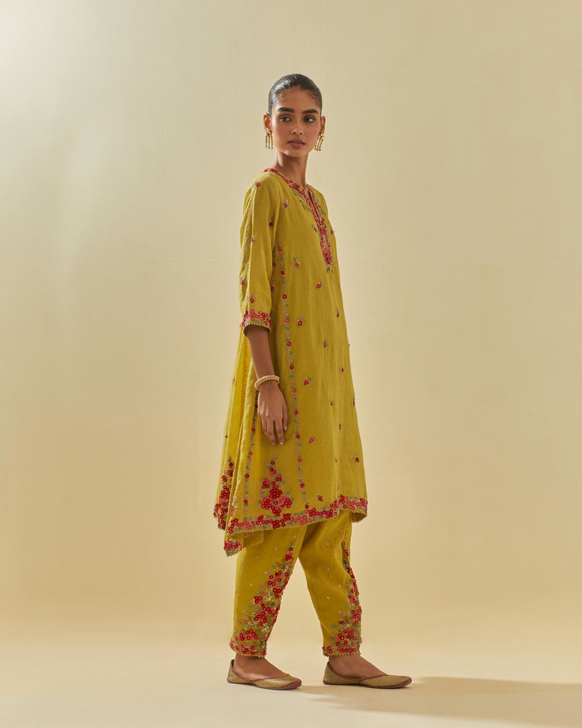 Yellow tissue chanderi mid length kalidar kurta set with hand cut silk flower embroidery, highlighted with gold sequins.