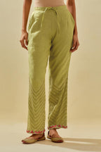 Green tissue chanderi straight pants with hand cut silk flower embroidery at hem, highlighted with gold sequins and beads.
