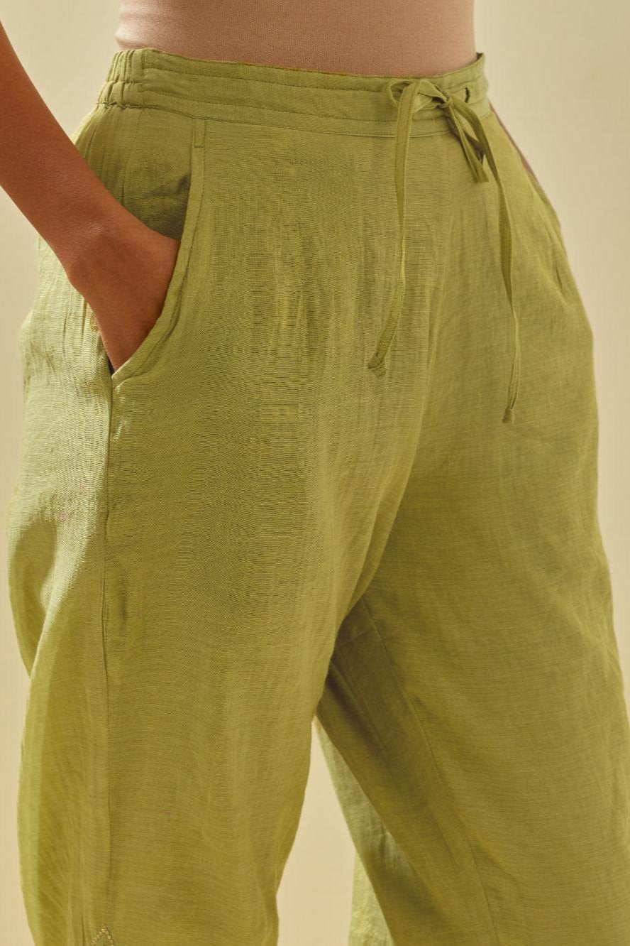Green tissue chanderi straight pants with hand cut silk flower embroidery at hem, highlighted with gold sequins and beads.