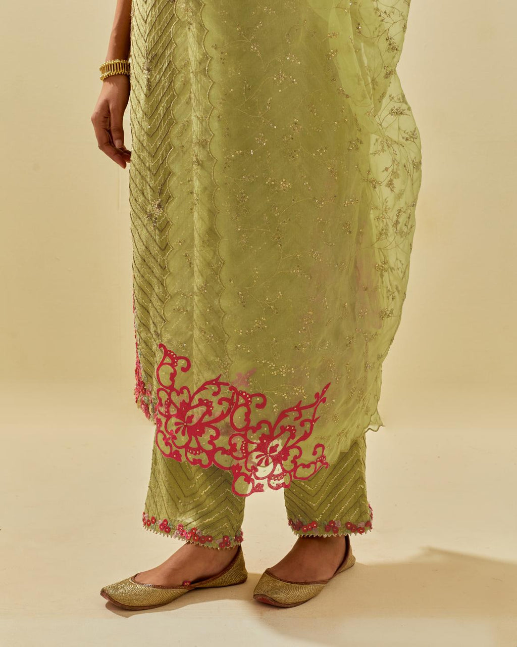 Green tissue chanderi straight kurta set with delicate hand cut silk flower embroidery, highlighted with gold sequins and beads.