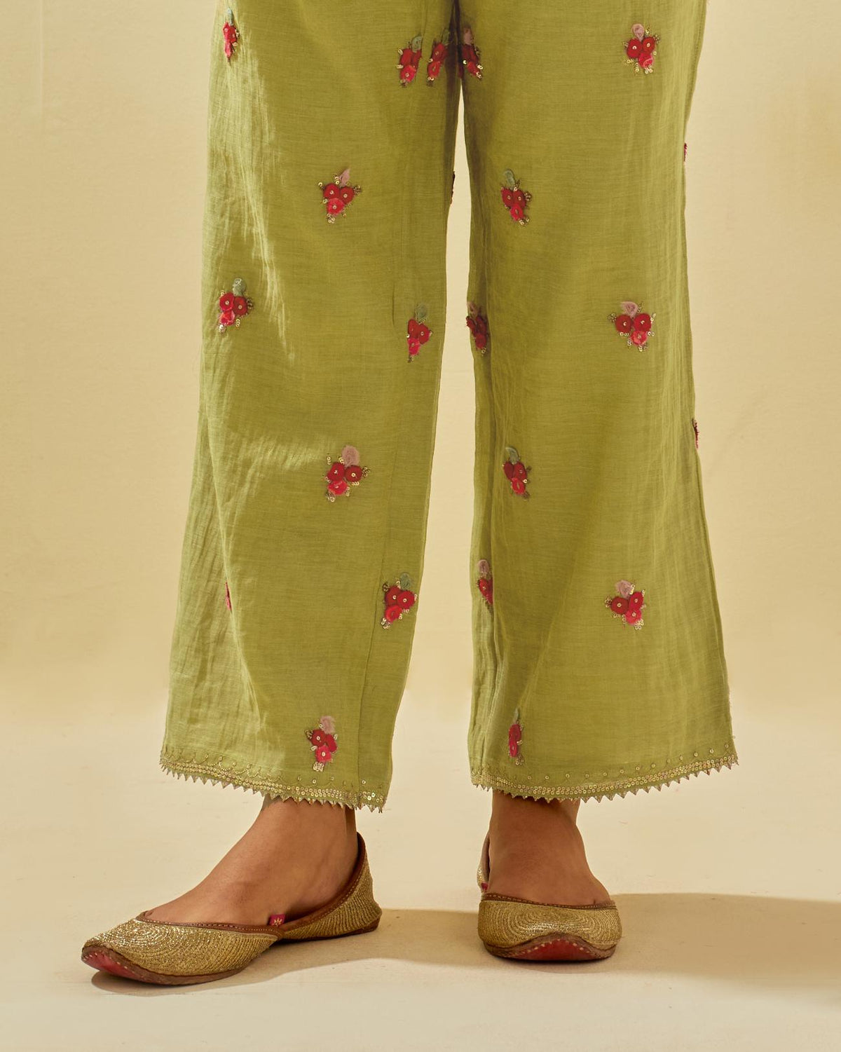 Green tissue chanderi straight pants with hand cut silk flower embroidered booti, highlighted with gold sequins.