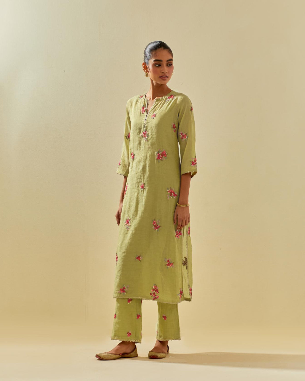 Green tissue chanderi straight kurta set with randomly placed hand cut silk flower bunches, highlighted with gold sequins.