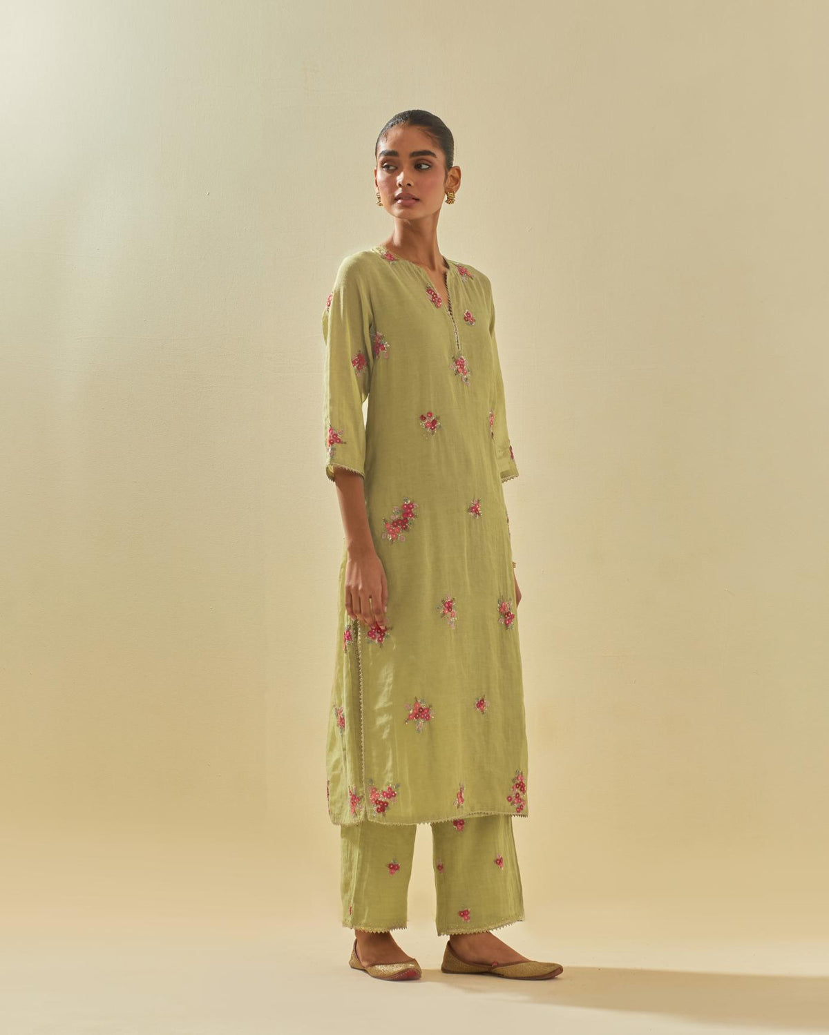 Green tissue chanderi straight kurta set with randomly placed hand cut silk flower bunches, highlighted with gold sequins.