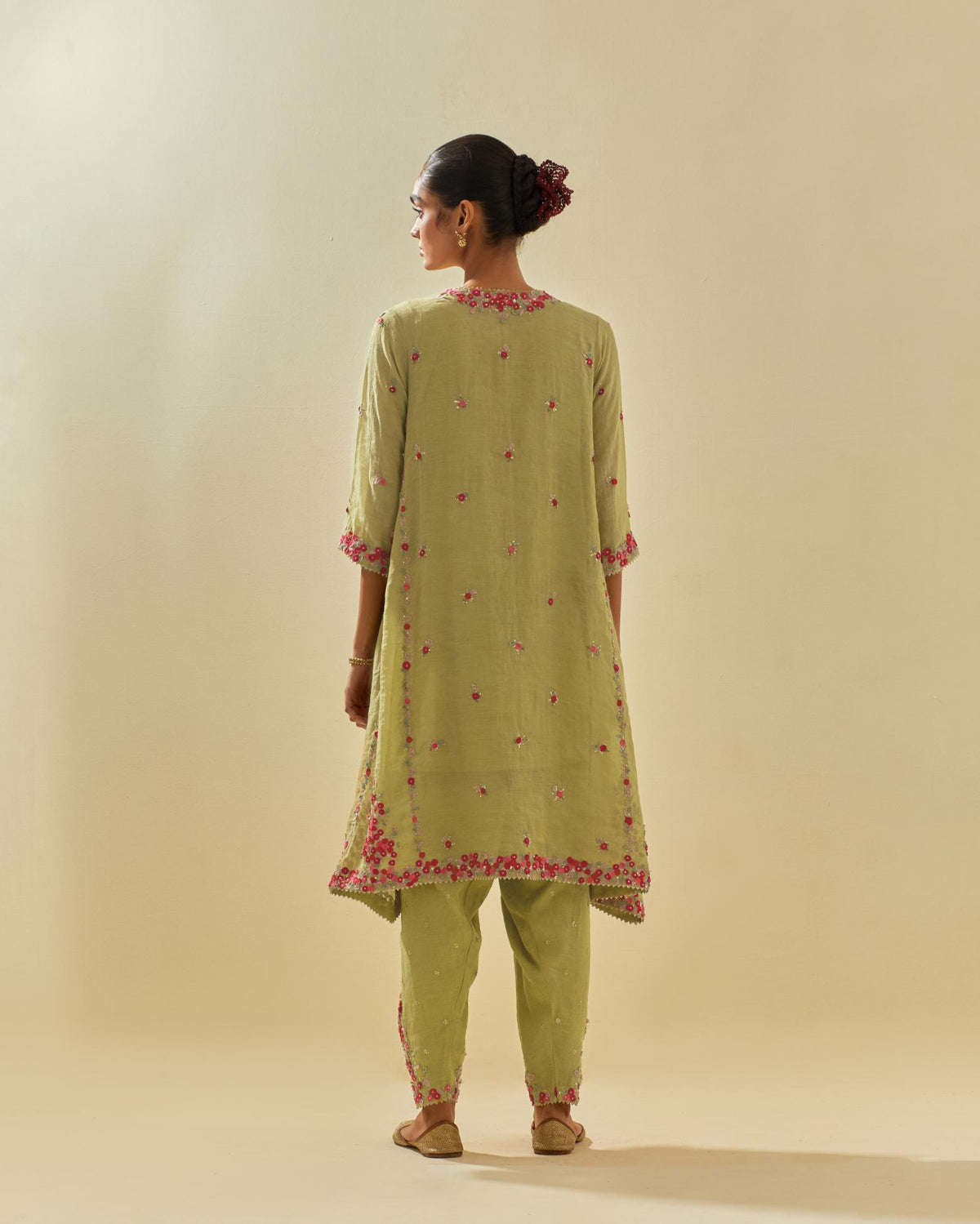 Green tissue chanderi mid length kalidar kurta set with hand cut silk flower embroidery, highlighted with gold sequins.