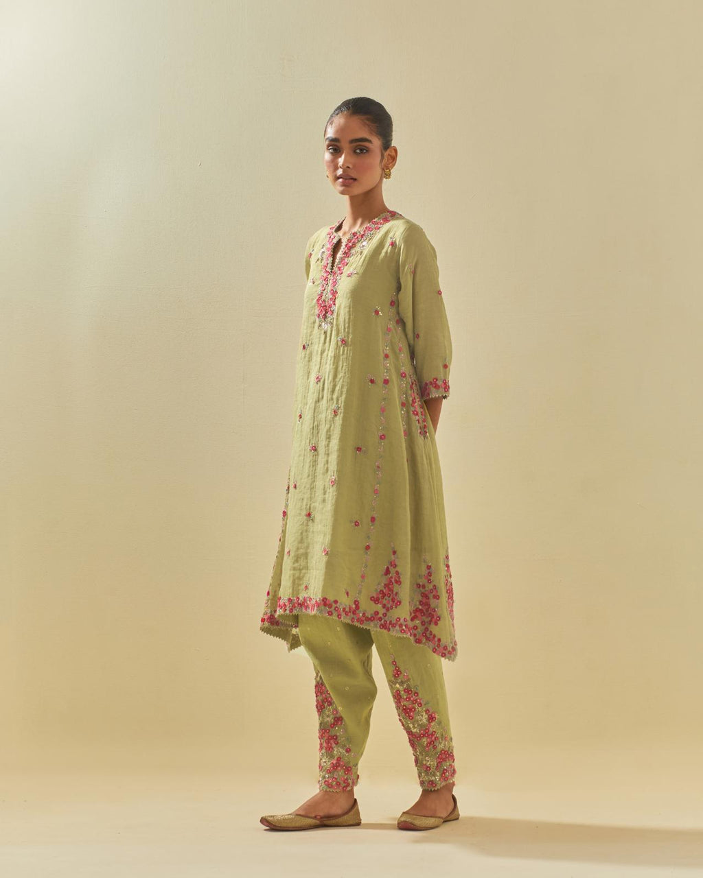 Green tissue chanderi mid length kalidar kurta set with hand cut silk flower embroidery, highlighted with gold sequins.