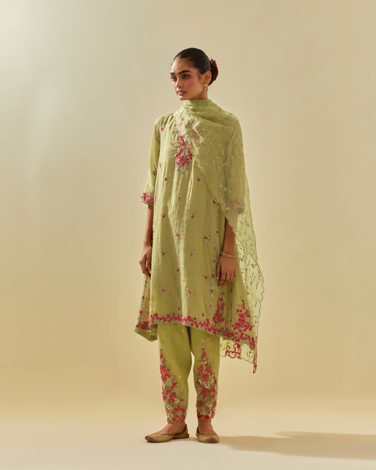 Green tissue chanderi mid length kalidar kurta set with hand cut silk flower embroidery, highlighted with gold sequins.
