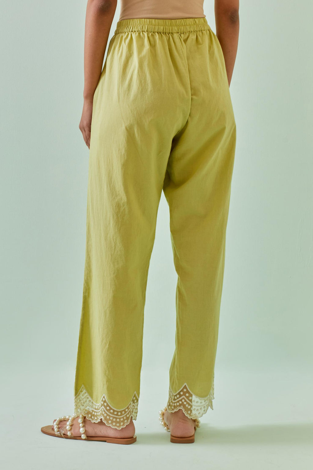 Green straight pants with scalloped embroidery at bottom hem.