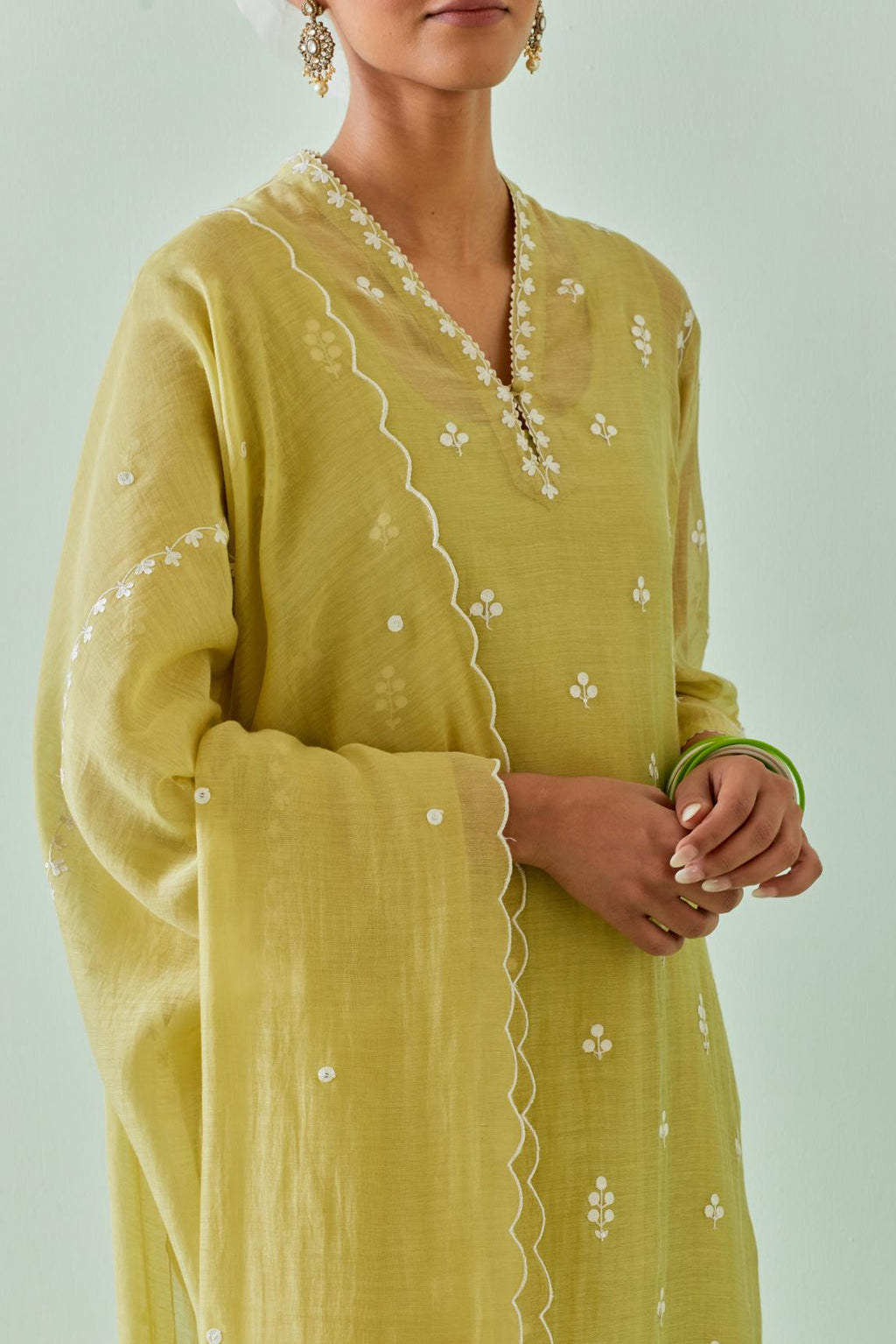 Green cotton chanderi dupatta with all-over off white embroidery and scalloped edges.