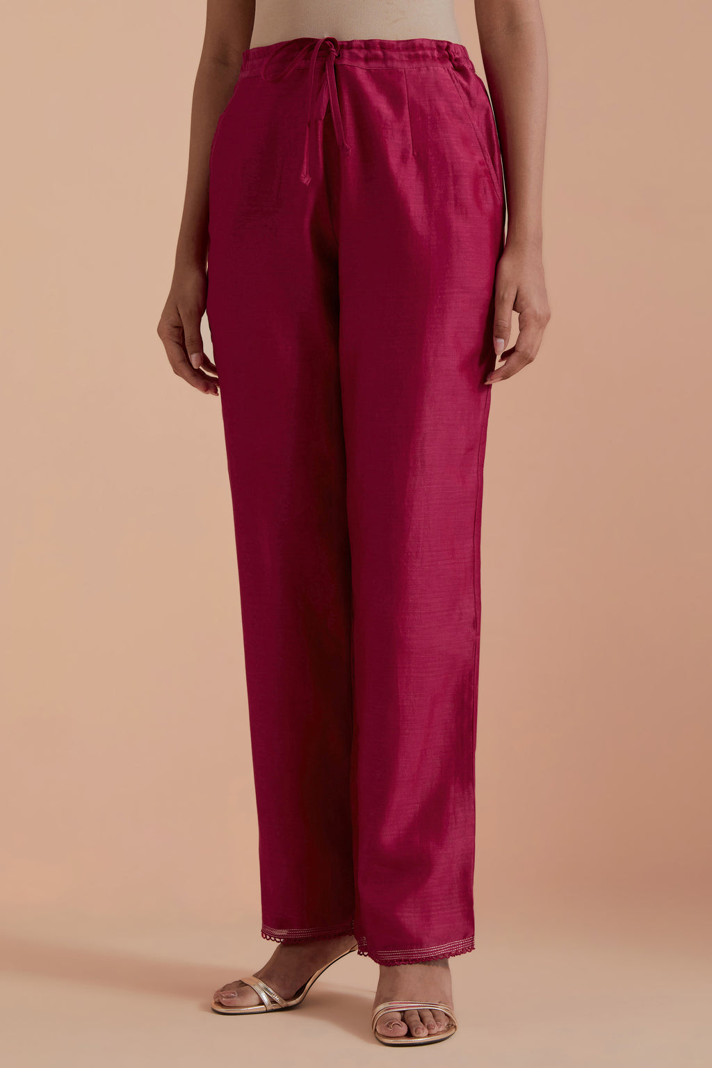Fuchsia silk chanderi straight pants detailed with scalloped organza edging at the hem, delicately highlighted with gold zari quilting.