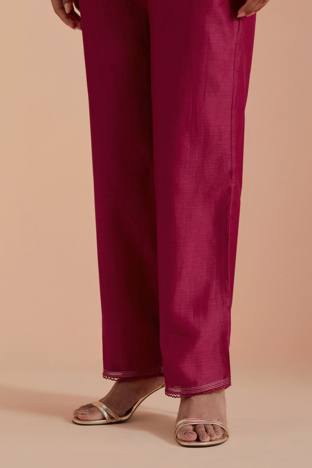 Fuchsia silk chanderi straight pants detailed with scalloped organza edging at the hem, delicately highlighted with gold zari quilting.