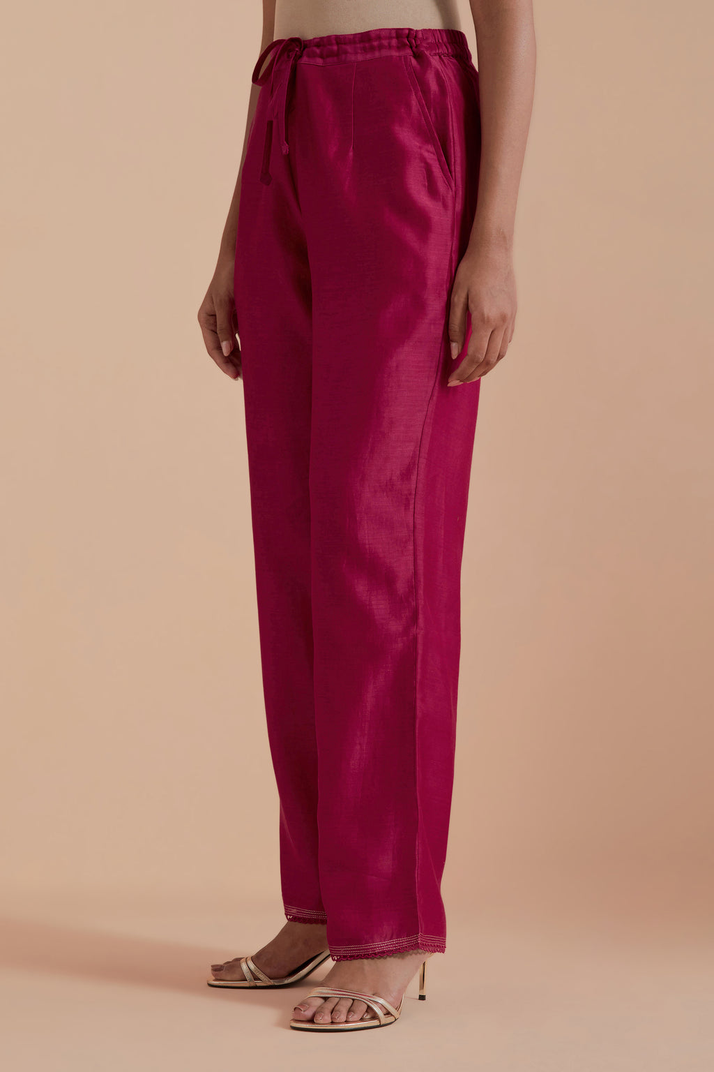 Fuchsia silk chanderi straight pants detailed with scalloped organza edging at the hem, delicately highlighted with gold zari quilting.
