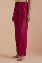 Fuchsia silk chanderi straight pants detailed with scalloped organza edging at the hem, delicately highlighted with gold zari quilting.