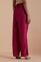 Fuchsia silk chanderi straight pants detailed with scalloped organza edging at the hem, delicately highlighted with gold zari quilting.