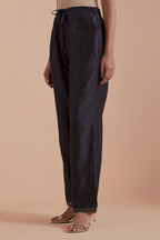 Dark grey silk chanderi straight pants detailed with scalloped organza edging at the hem, delicately highlighted with gold zari quilting.